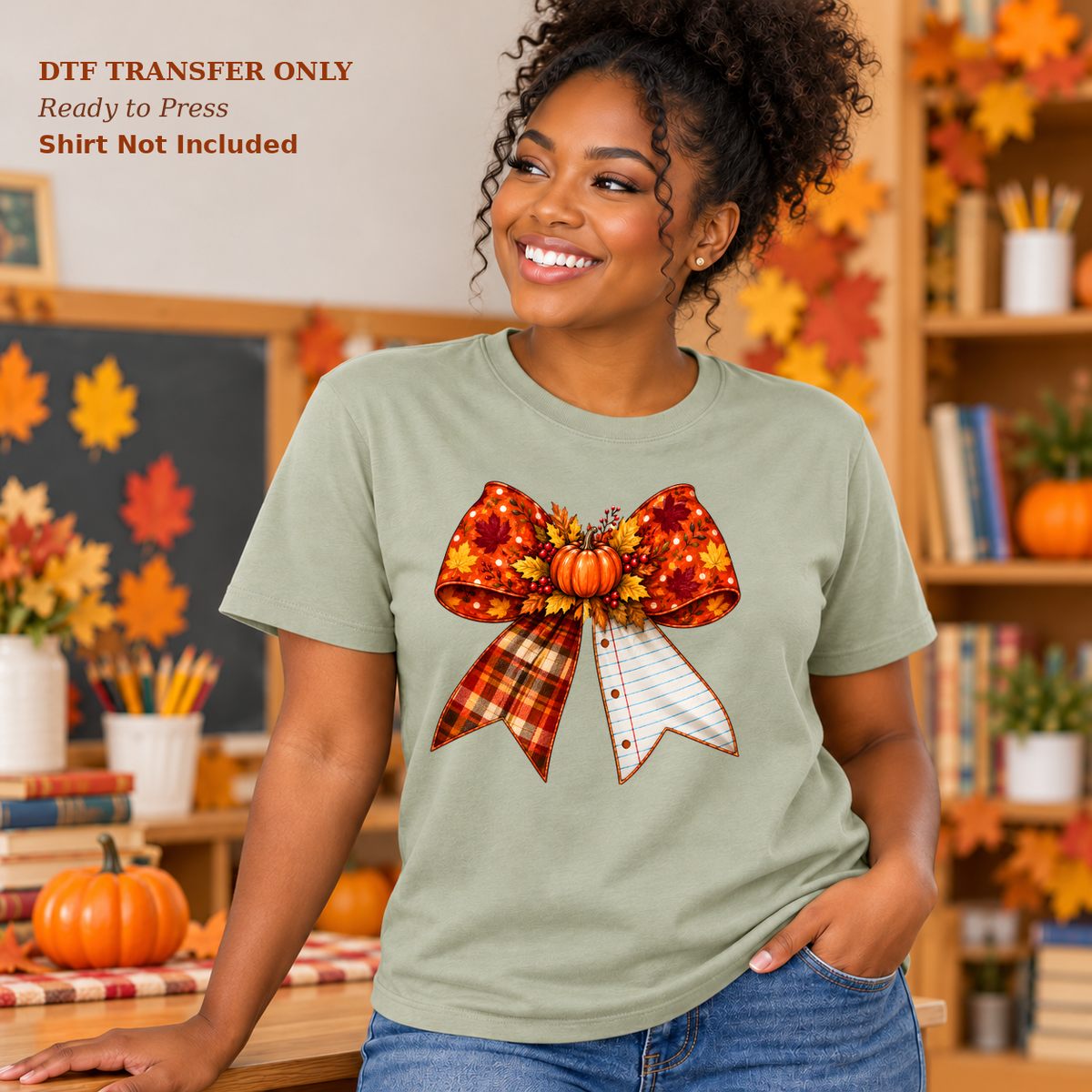 Woman in a sage shirt with a large orange fall bow, a small pumpkin, plaid ribbon, and a notebook-paper tail in a classroom.