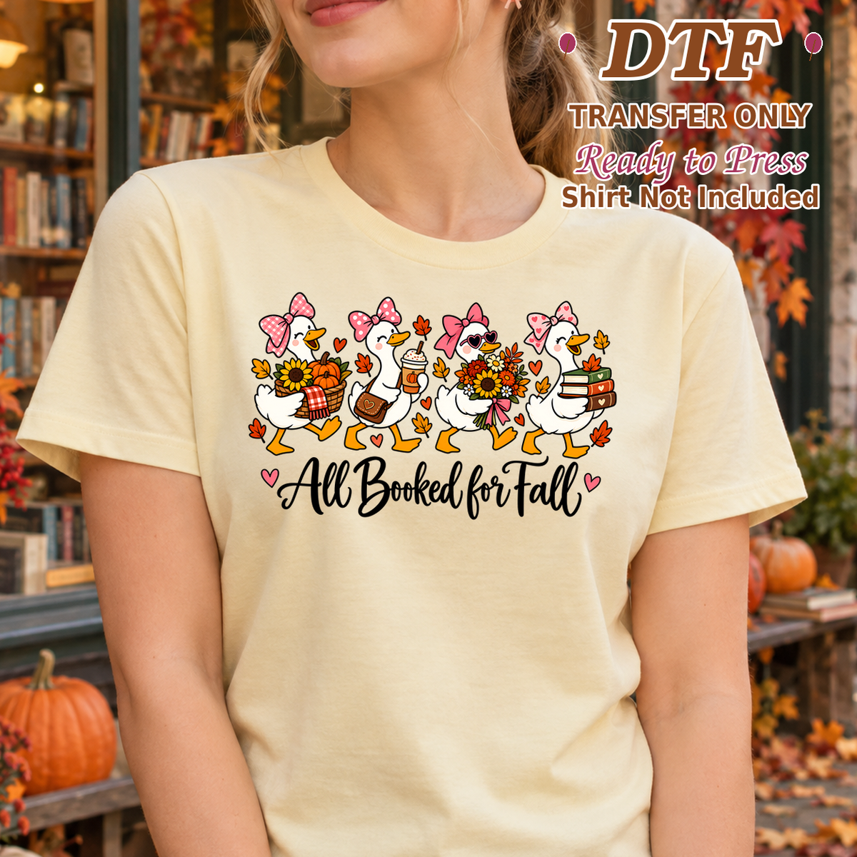 Woman in a pale yellow tee with book-carrying geese and dark All Booked for Fall script.