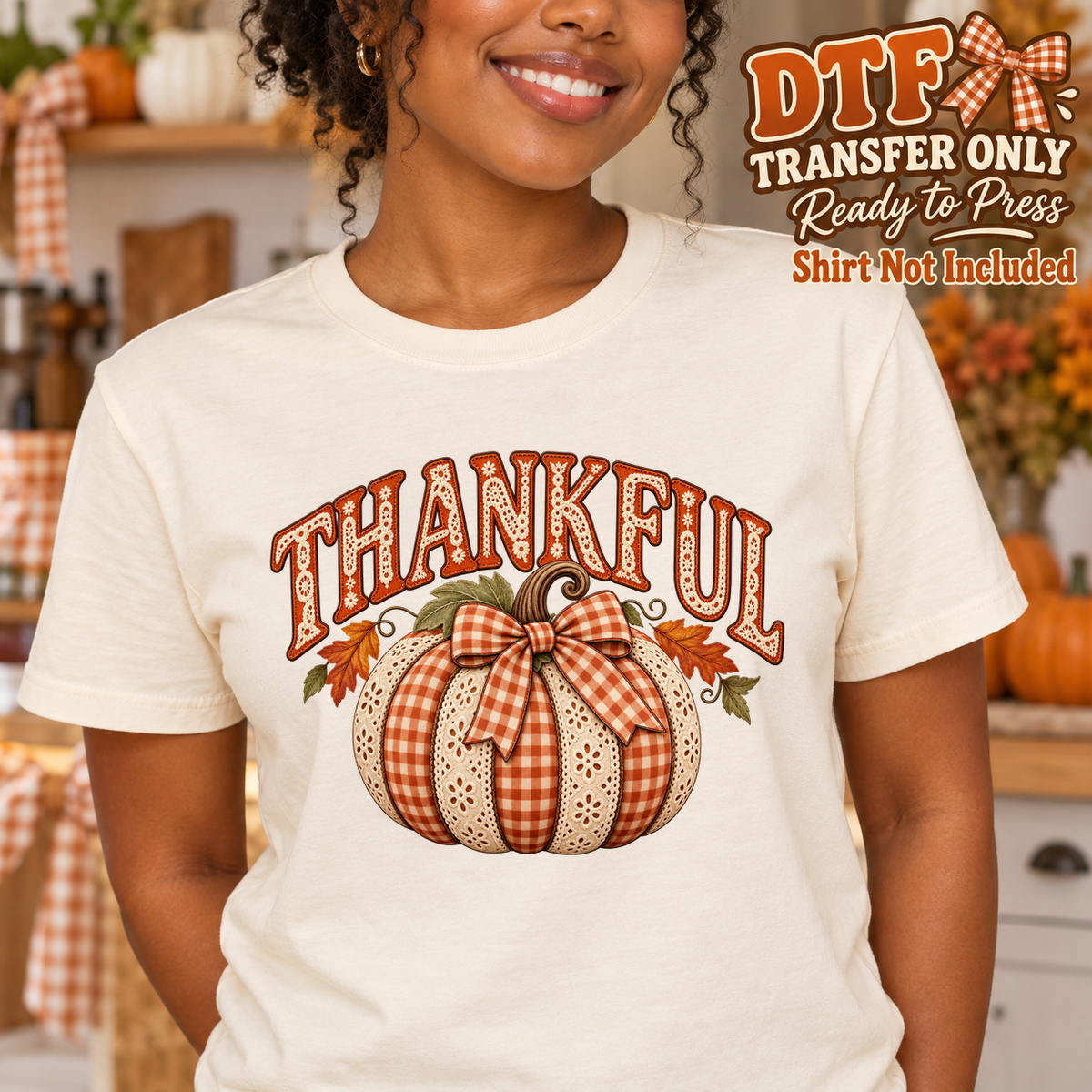 Woman in a cream tee with Thankful lettering and a patchwork pumpkin tied with a gingham bow.