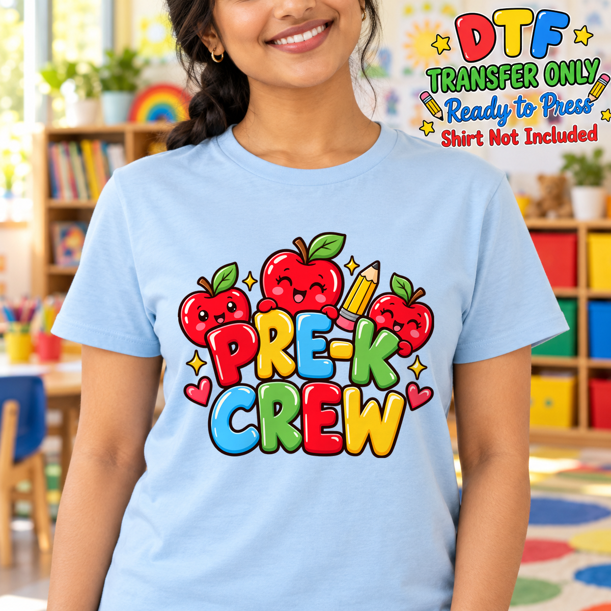 Woman in a blue tee with bright PRE K CREW lettering, apples and a pencil.