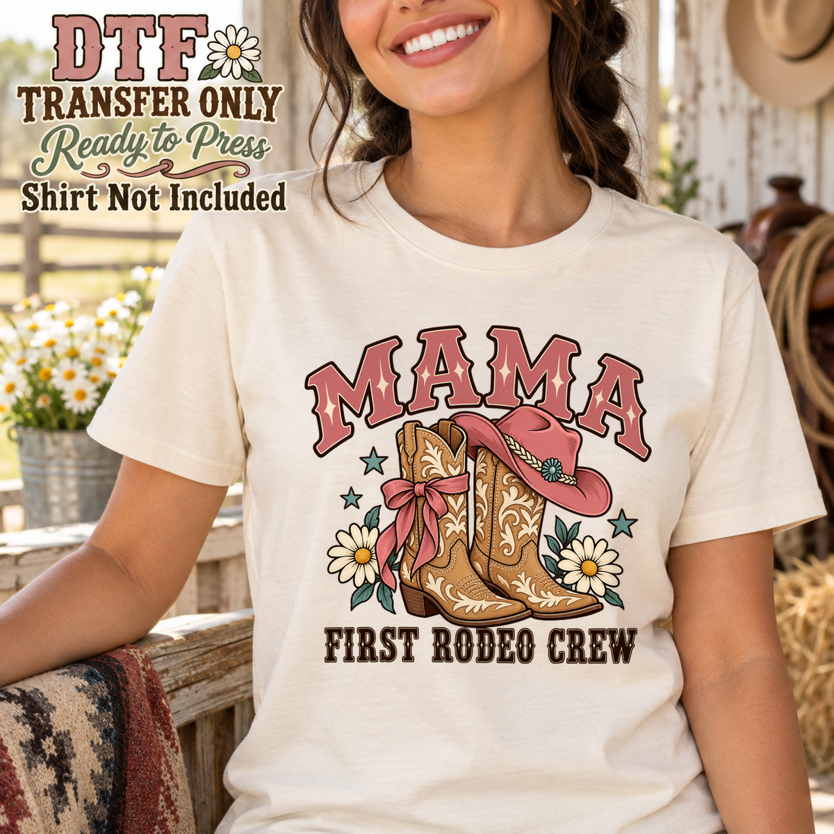 Woman in a cream tee with MAMA First Rodeo Crew text, western boots, a hat and flowers.