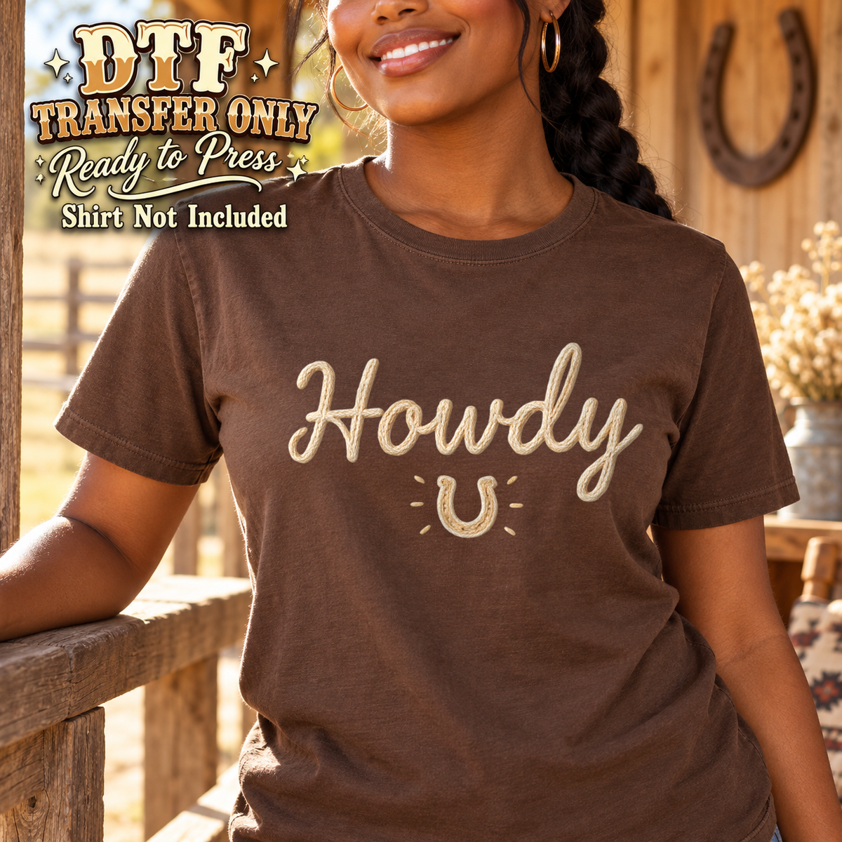 Woman in a brown tee with cream Howdy script and a small horseshoe.