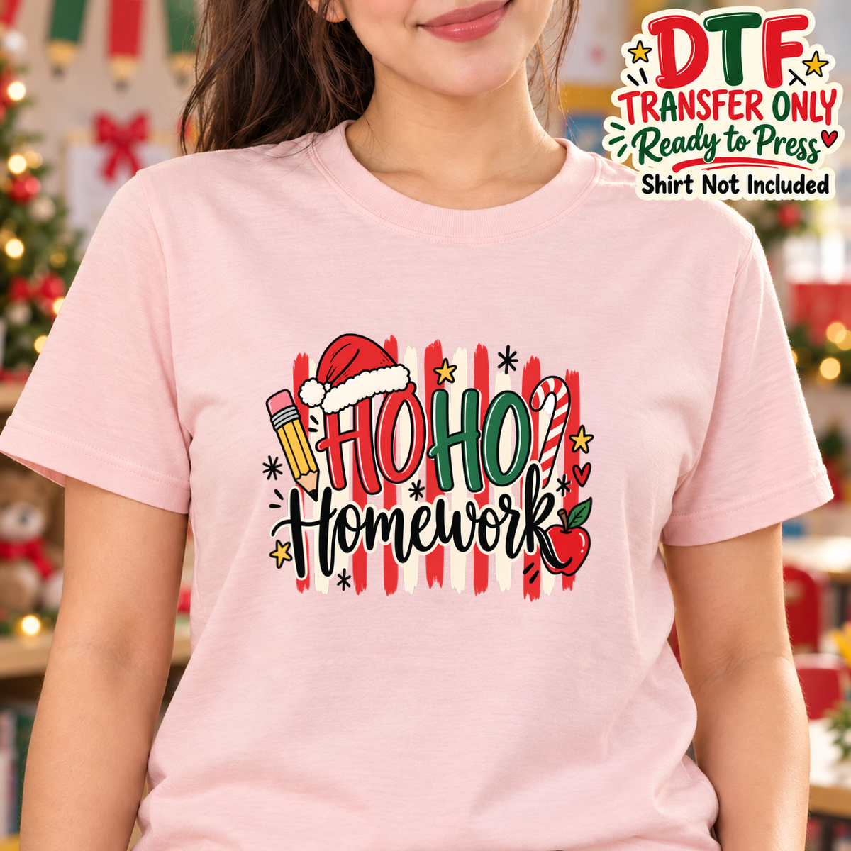 Woman in a pink tee with Ho Ho Homework text, a Santa hat, pencil and apple.