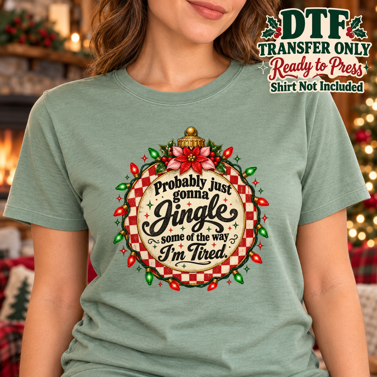 Woman in a sage tee with a festive ornament reading Probably just gonna Jingle some of the way I'm Tired.