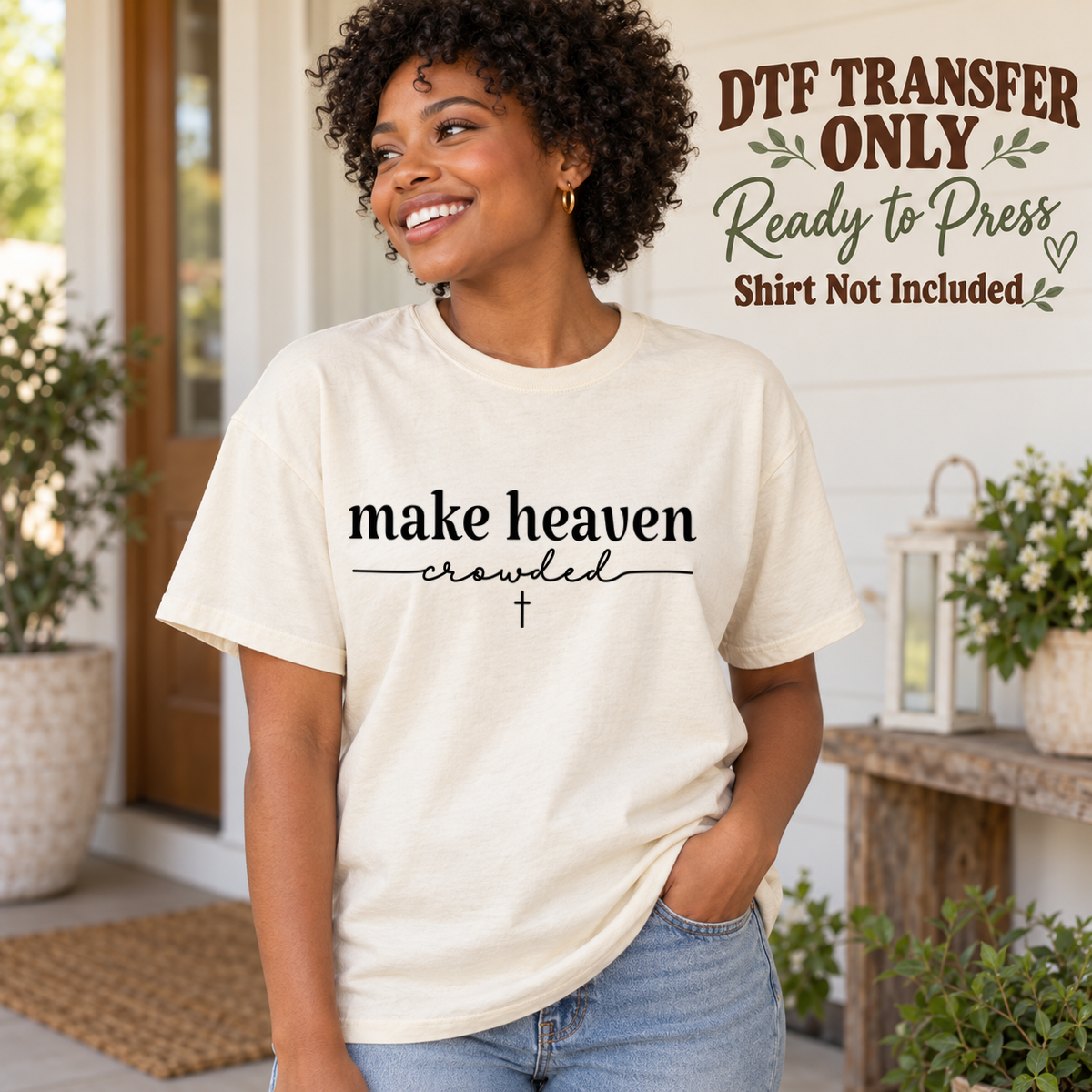 Woman in an ivory tee with black make heaven crowded lettering, a thin underline and a small cross, labeled DTF transfer only.