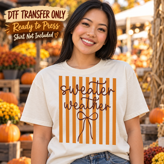 Woman in a white tee with orange vertical stripes, black Sweater Weather script and a line-drawn bow, labeled transfer only.