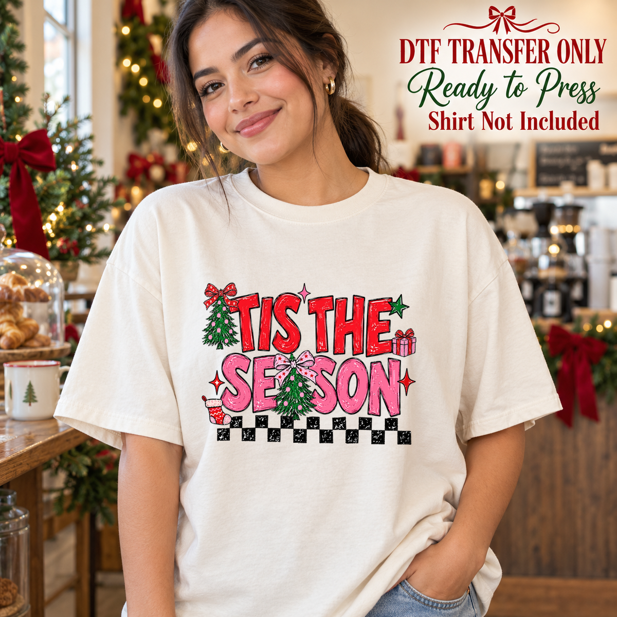 Woman in a cream tee displaying pink and red Tis the Season text, Christmas details and a black-and-white checkerboard, labeled transfer only.