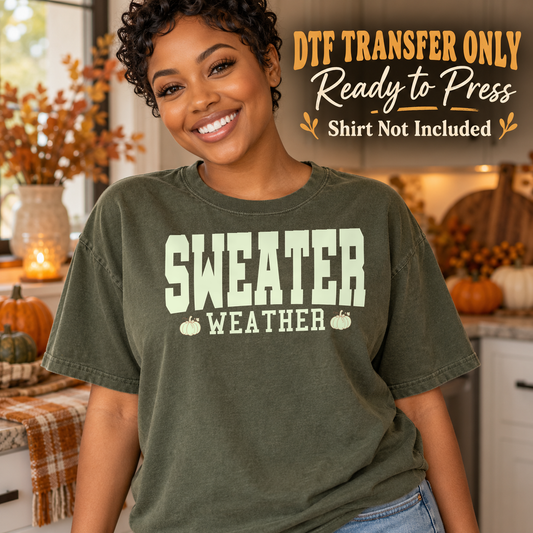 Woman in an olive tee showing cream Sweater Weather retro block lettering with small pumpkins, labeled DTF transfer only.