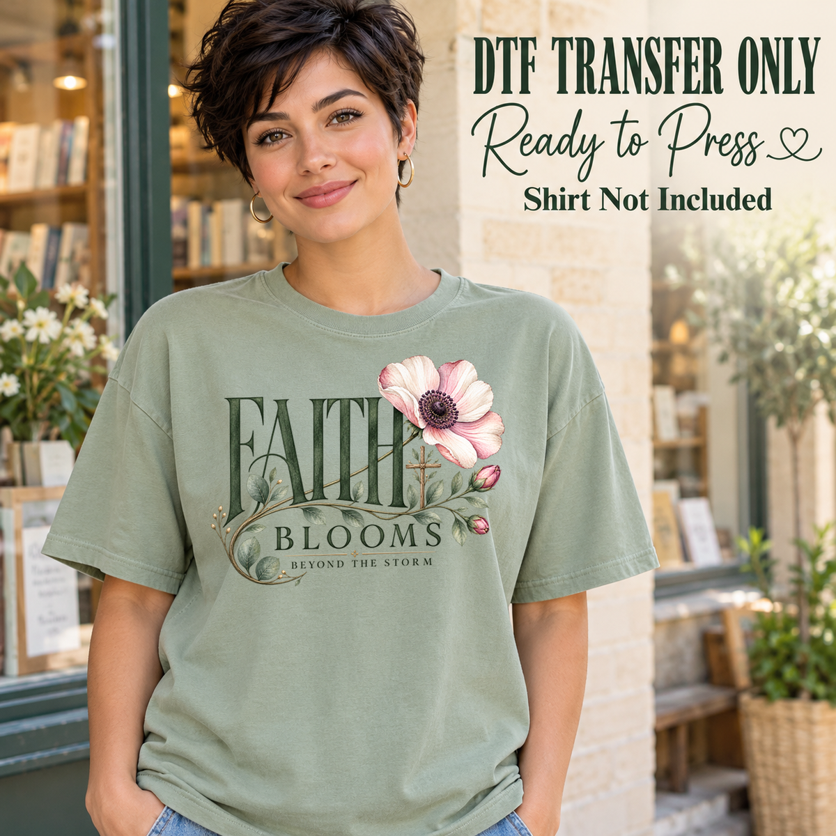 Woman in a sage green tee displaying Faith Blooms Beyond the Storm lettering with a pink flower and curling green stems, labeled transfer only.