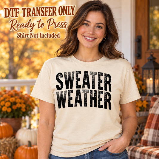 Woman in an ivory tee with large distressed black Sweater Weather lettering in two lines, labeled DTF transfer only.