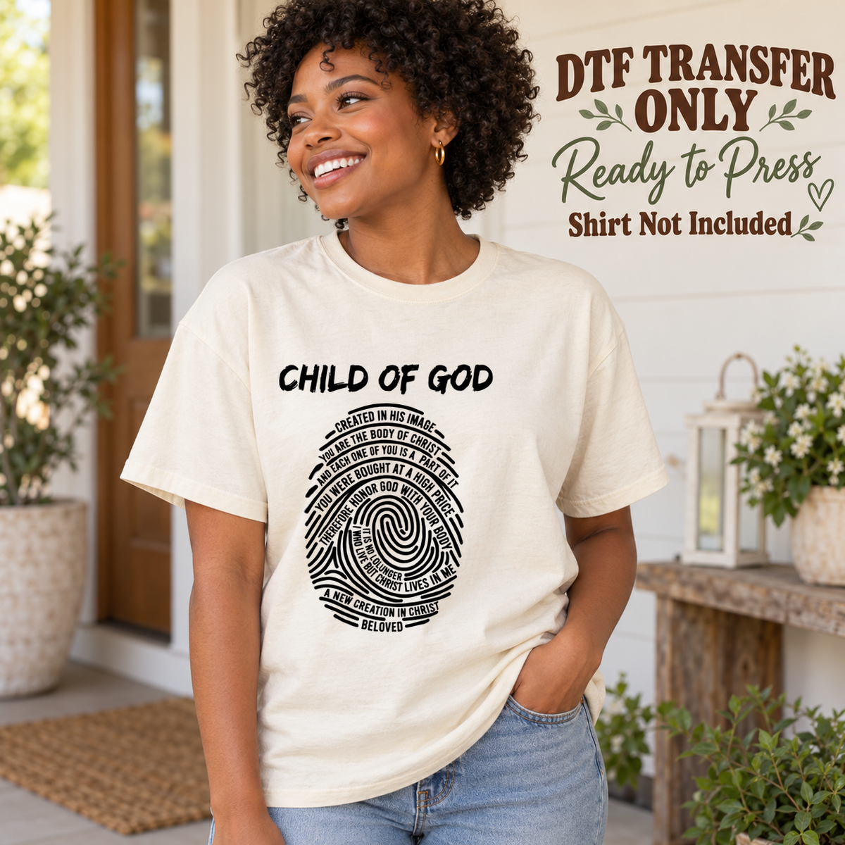 Woman in an ivory tee displaying Child of God above a black fingerprint formed from small faith-related words, labeled transfer only.