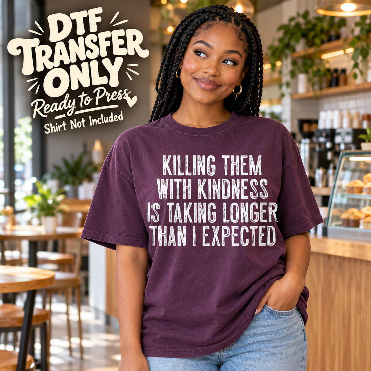 Woman in a plum tee with white Killing Them With Kindness Is Taking Longer Than I Expected lettering, labeled transfer only.