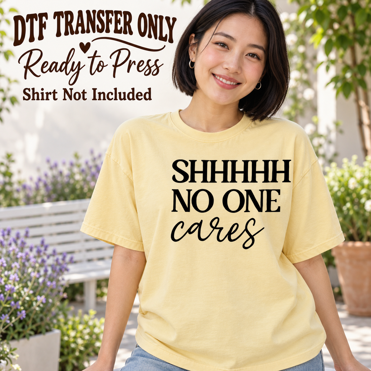 Woman in a pale yellow tee displaying black Shhhh No One Cares text in serif and script lettering, labeled DTF transfer only.