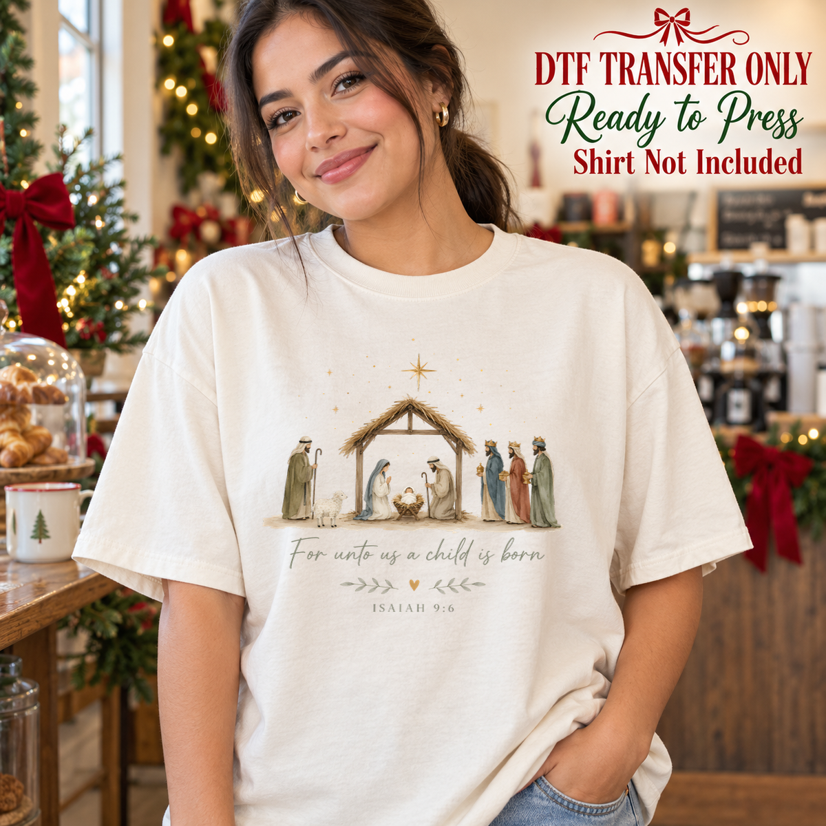 Woman in an ivory tee with a nativity scene, star, For Unto Us a Child Is Born wording and Isaiah 9:6 reference, labeled transfer only.