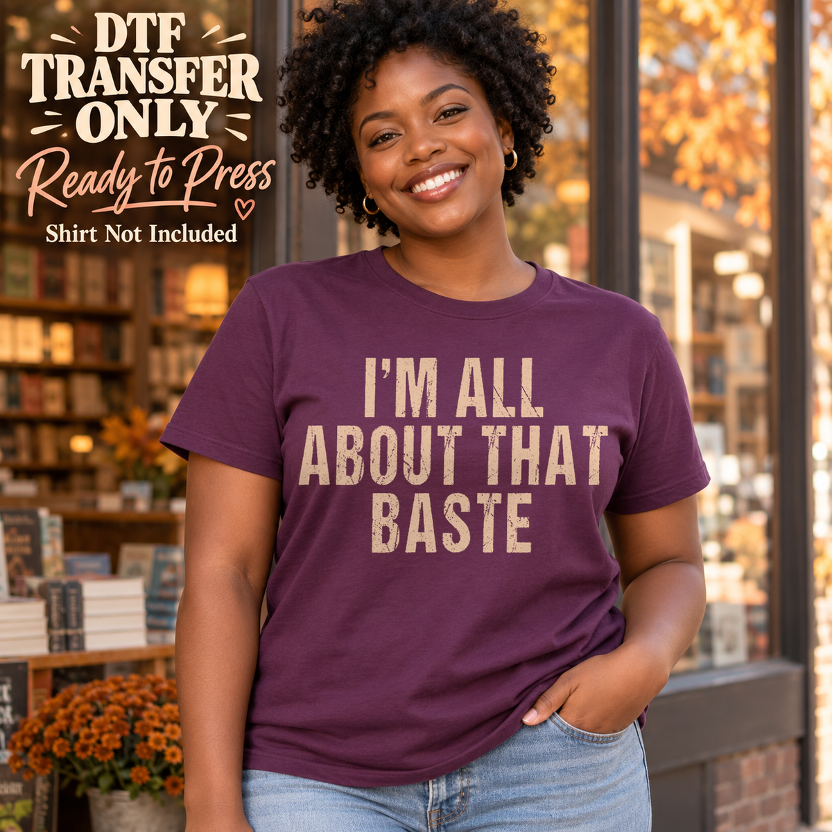 Woman in a plum tee with warm cream I'm All About That Baste block lettering, labeled DTF transfer only.