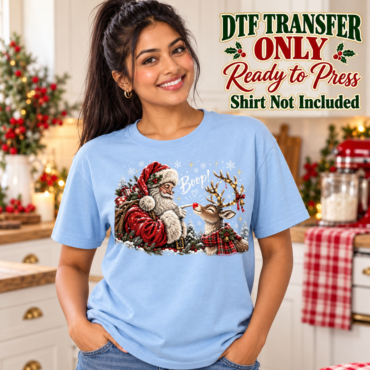Woman in a light blue tee showing Santa touching a reindeer's red nose with Boop text and snowy accents, labeled DTF transfer only.