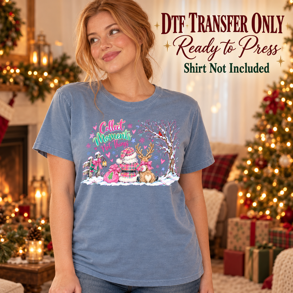 Woman in a blue tee with Collect Moments Not Things text above Santa and a reindeer seen from behind in a snowy pink-accented scene, labeled transfer only.