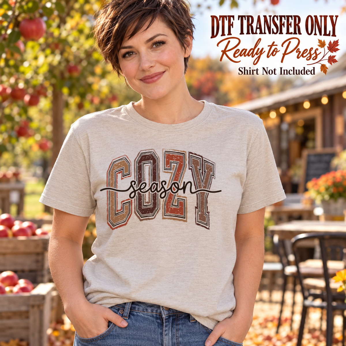 Woman in a light gray tee showing earth-tone outlined COZY lettering with black Season script across it, labeled DTF transfer only.