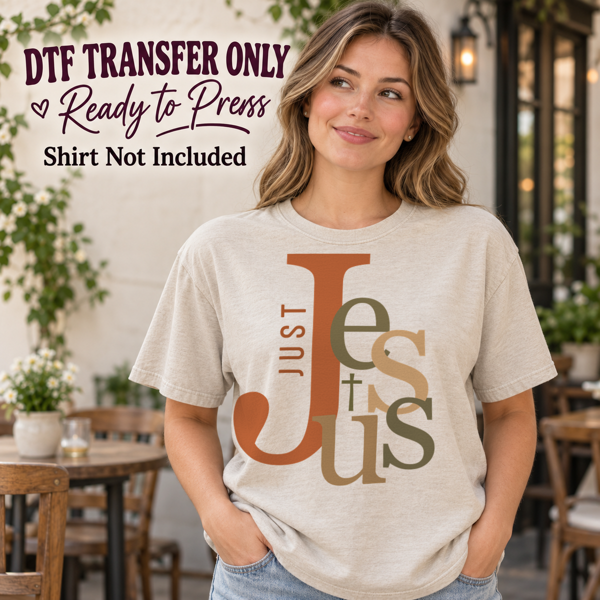 Overlapping earth-tone JESUS typography with vertical JUST text, shown on a cream shirt model mockup; physical DTF transfer only, shirt not included.