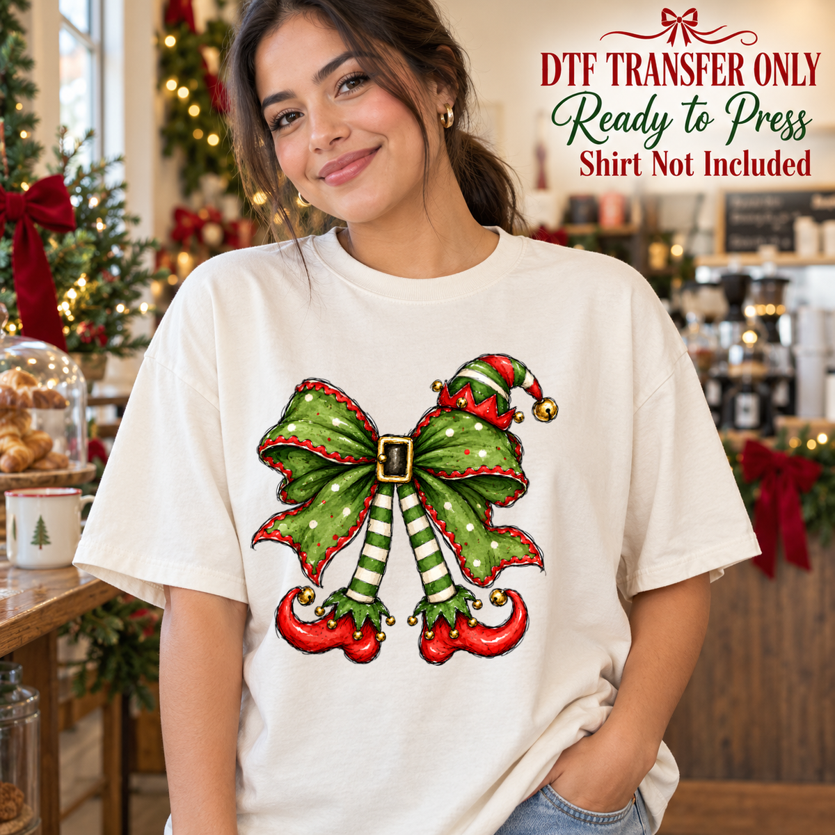 Green and red Christmas bow with belt detail and curled elf shoes, shown on a white shirt model mockup; physical DTF transfer only, shirt not included.