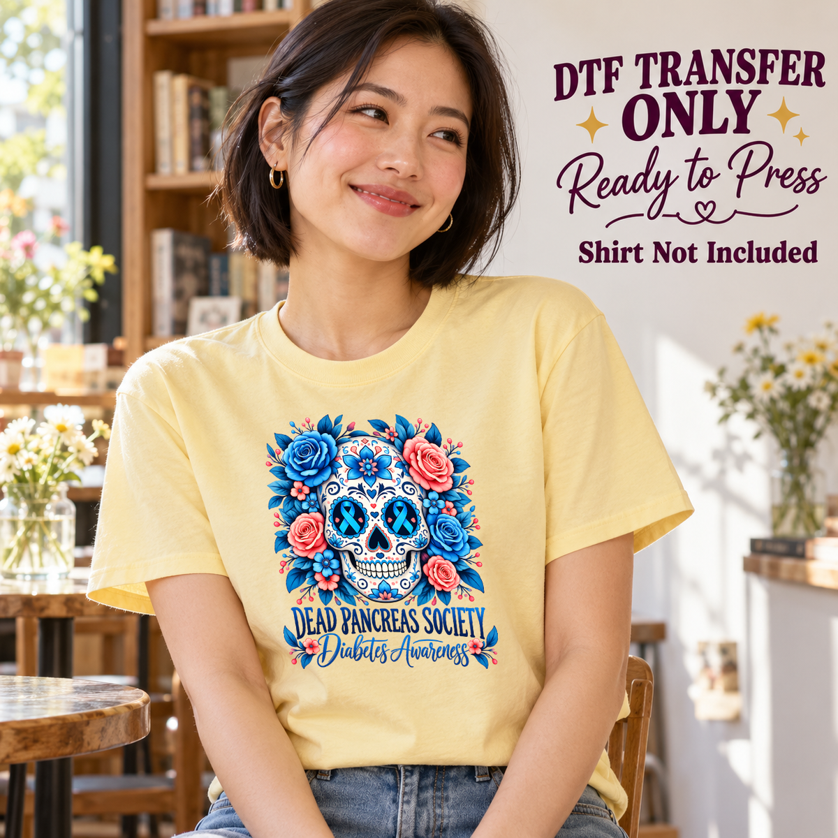 Model wearing a yellow shirt showing blue floral sugar skull with Dead Pancreas Society and Diabetes Awareness dark text; DTF transfer only, shirt not included.