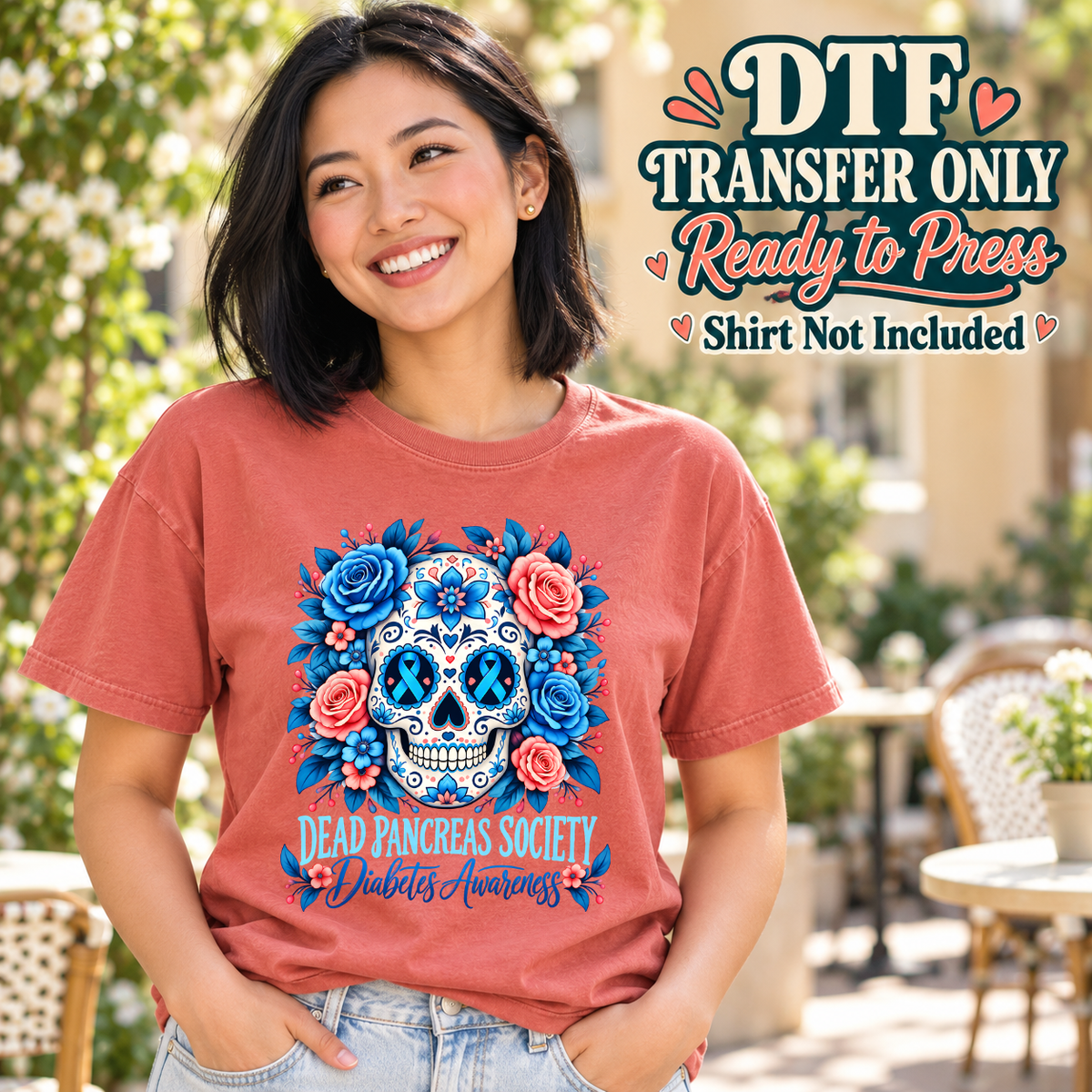 Model wearing a coral shirt showing blue floral sugar skull with Dead Pancreas Society and Diabetes Awareness light text; DTF transfer only, shirt not included.