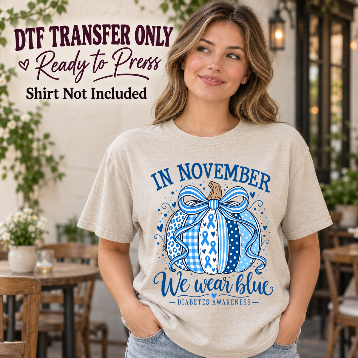 Model wearing a cream shirt showing In November We Wear Blue with a ribbon-patterned pumpkin and blue bow; DTF transfer only, shirt not included.