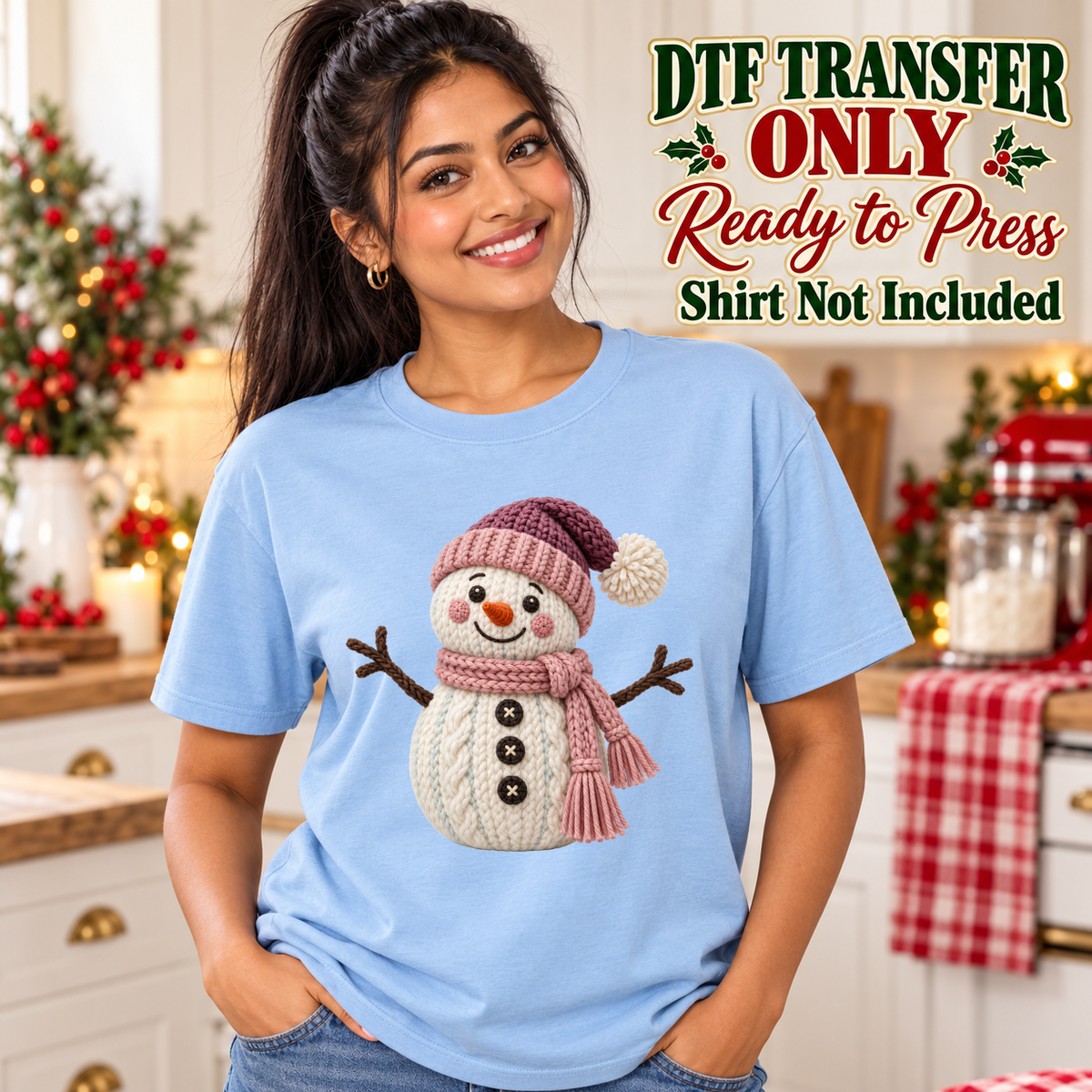 Model wearing a light blue shirt showing knit-look snowman wearing a pink hat and scarf; DTF transfer only, shirt not included.