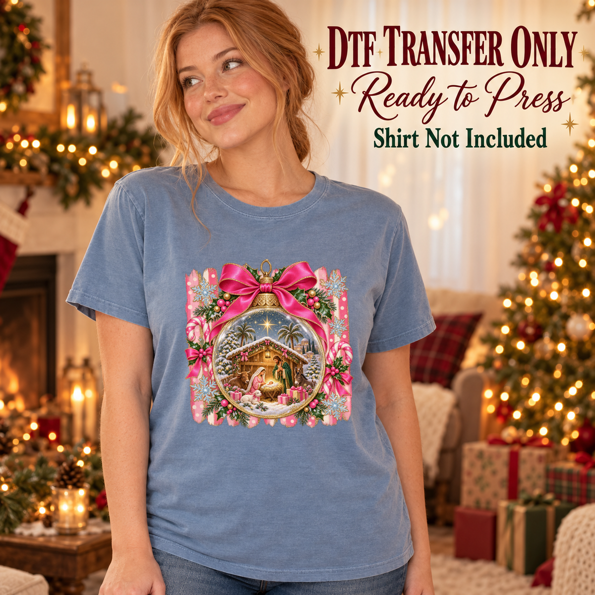 Model wearing a blue shirt showing nativity scene in an ornament framed by pink flowers and a bow; DTF transfer only, shirt not included.