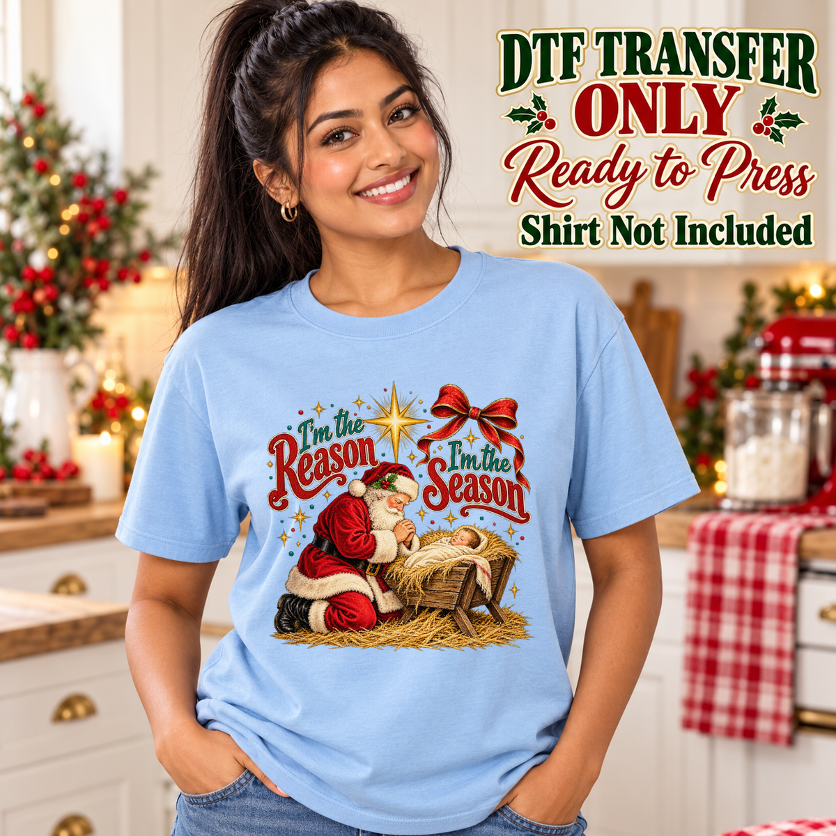Model wearing a light blue shirt with jesus and santa beside manger with reason and season wording; DTF transfer only, shirt not included.