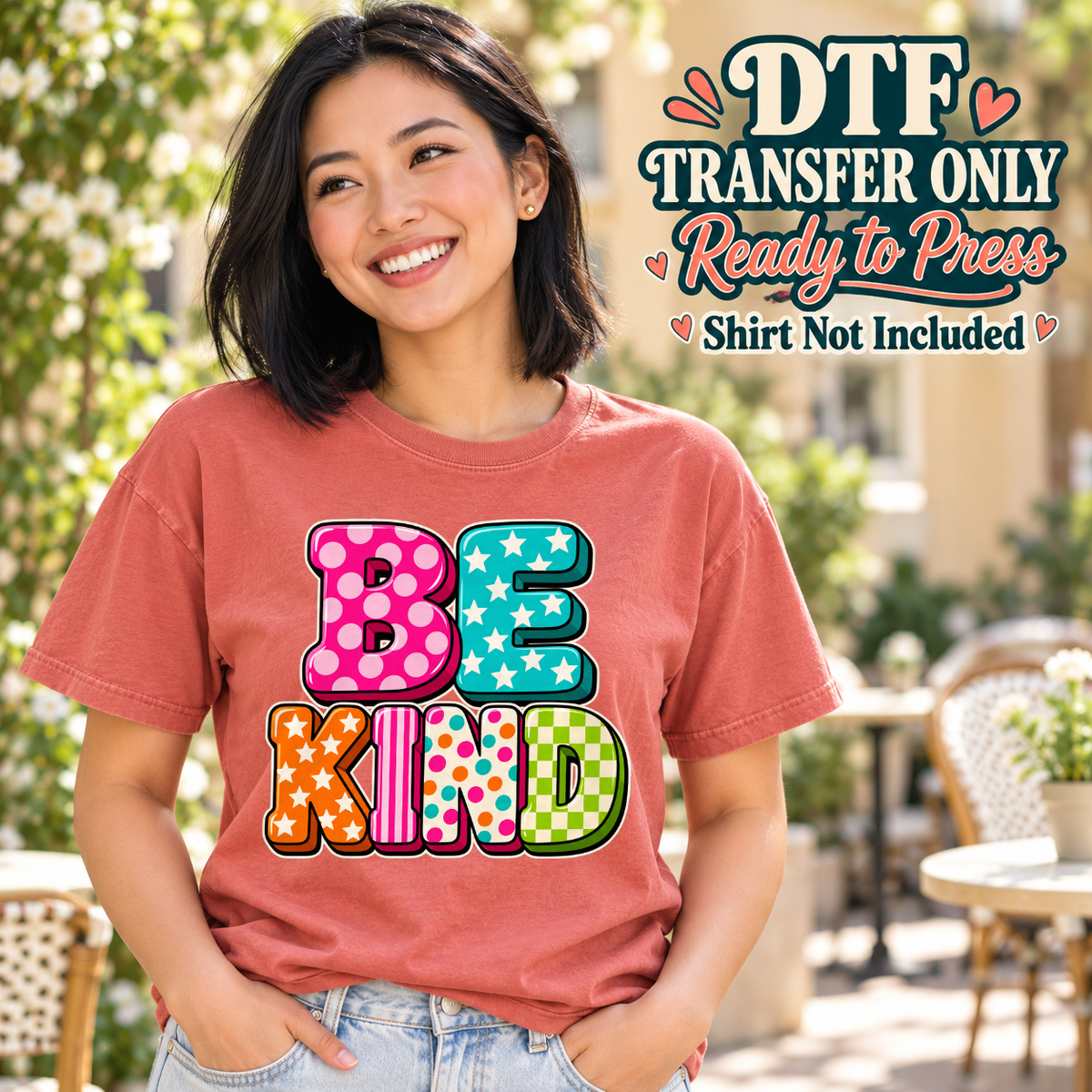 Model wearing a coral shirt with be kind letters with polka dots stripes stars and checks; DTF transfer only, shirt not included.