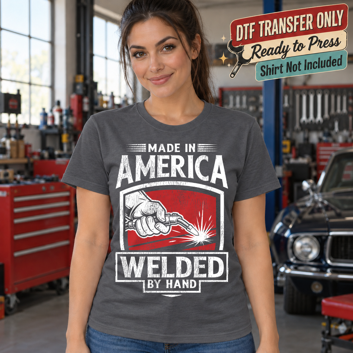 Made in America Welded by Hand design with welding sparks shown on a charcoal shirt worn by a woman; DTF transfer only, shirt not included.