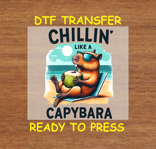 Chillin' Like a Capybara DTF transfer showcasing a relaxed capybara in sunglasses sipping from a coconut against a beachy background.