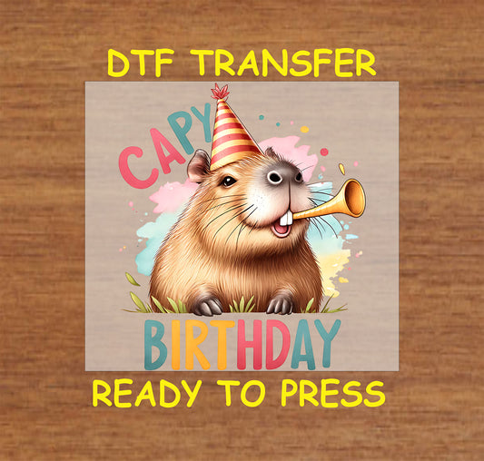 "Capy Birthday" DTF transfer with a cheerful capybara in a party hat blowing a party horn on a colorful background.