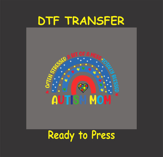 Autism Mom DTF transfer with a rainbow, puzzle pieces, and text reading "Often Stressed, A Bit of a Mess, Totally Blessed" on a gray background.