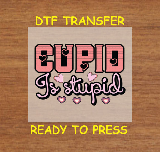 "Bold pink and black 'Cupid Is Stupid' anti-Valentine design with hearts for heat press projects."