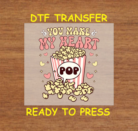 Retro popcorn bucket with hearts and “You Make My Heart Pop” text, ready to press DTF transfer.