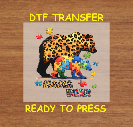 "DTF transfer featuring a puzzle piece mama bear with a leopard print design, a colorful puzzle piece baby bear, and the phrase 'MAMA BEAR' in bold lettering."
