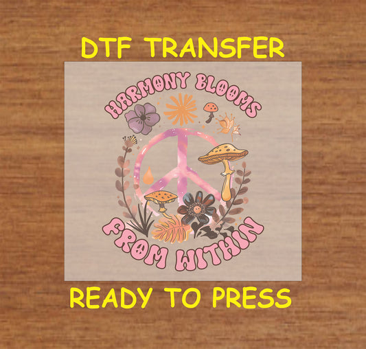 "DTF transfer featuring a peace sign surrounded by flowers and mushrooms with the phrase 'Harmony Blooms From Within' in retro-style lettering."