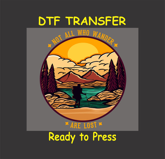 "DTF transfer with a scenic hiker design, mountains, a lake, and the text 'Not All Who Wander Are Lost', ready to press."
