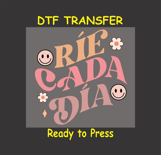 "Ríe Cada Día" Spanish phrase with smiley faces and floral accents, DTF transfer.