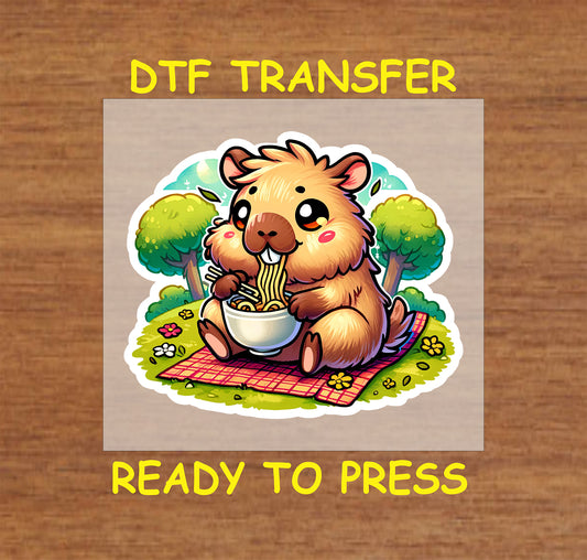 Chibi-style capybara eating ramen on a picnic blanket with trees in the background.