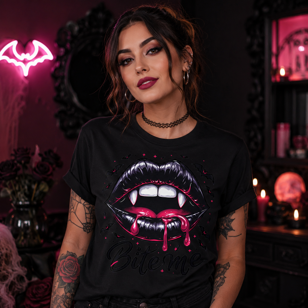 A woman wearing a black graphic t-shirt with a dripping vampire lips design and the text 'Bite Me', posed in a dark, gothic-themed room with candles and a neon bat sign.