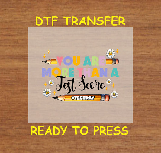 More Than a Test Score DTF transfer with colorful text, pencils, and smiley daisies.