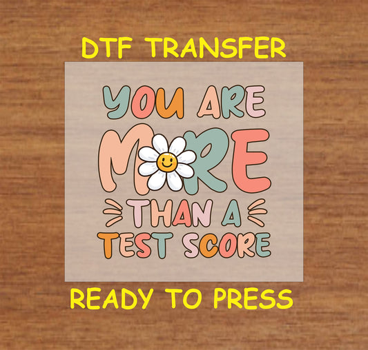 You Are More Than a Test Score DTF transfer with a retro daisy smiley and colorful text.