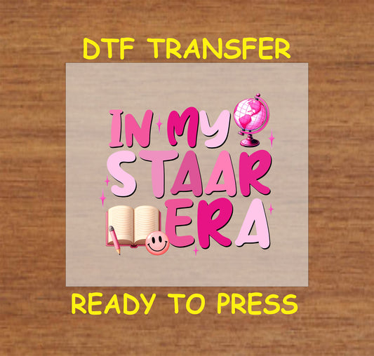 In My STAAR Era DTF transfer with pink text, a globe, book, and smiley face.
