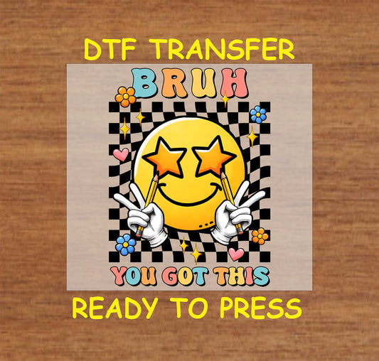 Bruh You Got This DTF transfer with a star-eyed smiley, checkered background, and peace sign hands holding pencils.