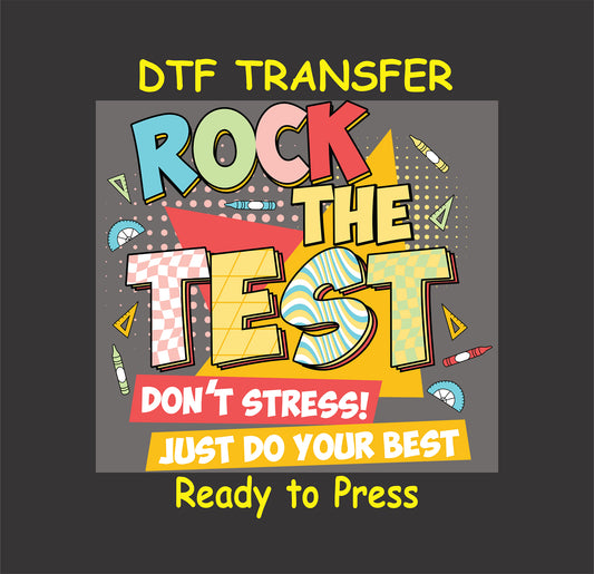 Rock the Test DTF transfer with bold, colorful comic-style text and school supplies.