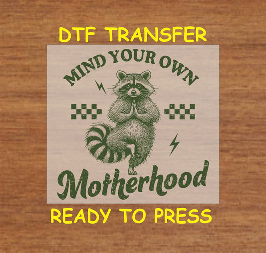 Mind Your Own Motherhood DTF transfer with a meditating raccoon, checkered pattern, and lightning bolts in a retro style.