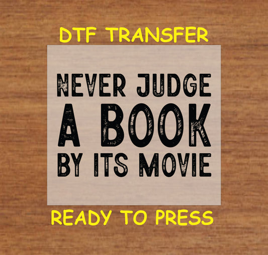 Never Judge a Book by Its Movie DTF transfer with bold, distressed lettering.